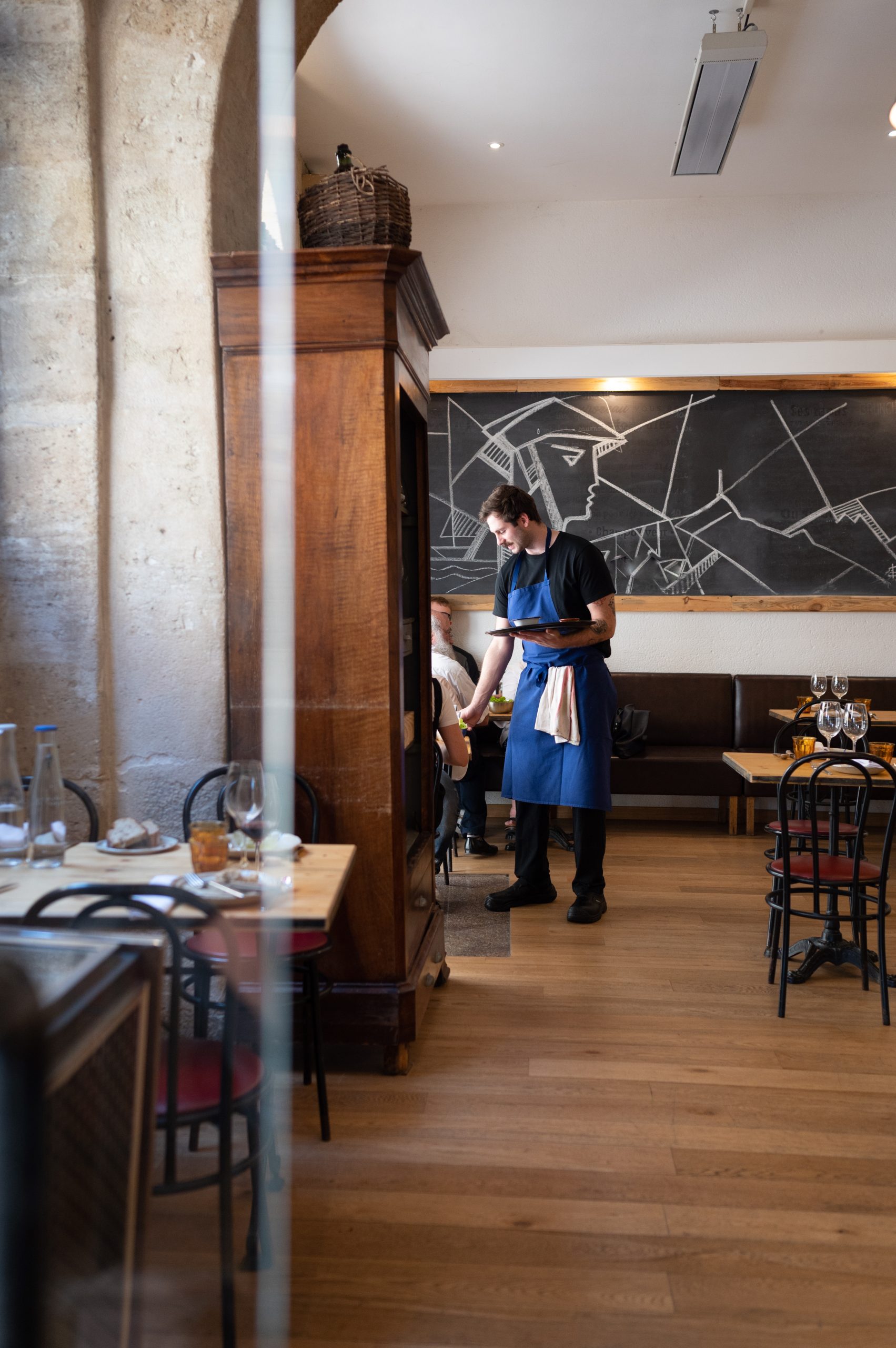 reportage-photographie-petillantes-productions serveur qui sert un plat dans un restaurant