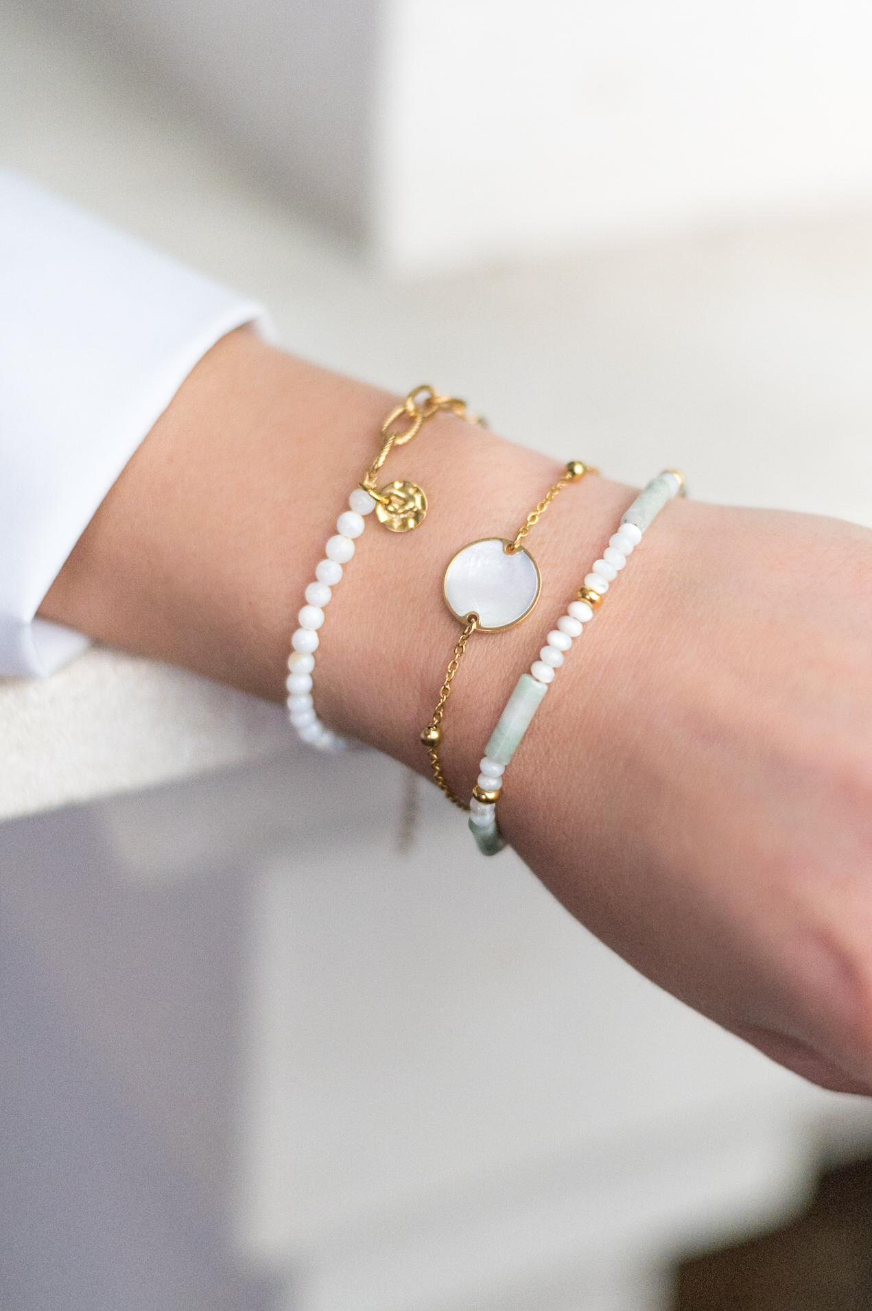photo-produit-petillantes-productions Femme portant des bracelets dorés et blancs au poignée